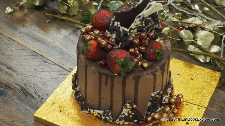 Christmas Cake decorated with chocolate shards, chocolate dipped strawberries and red currants