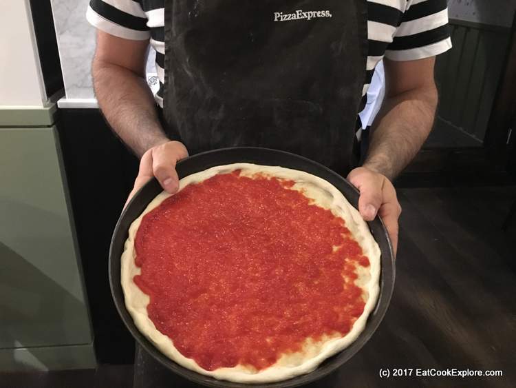 Pizza making adding sauce